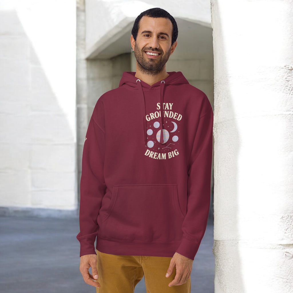 Man wearing maroon hoodie with dream big stay grounded printed on it - Orbit Clothing - Unisex 
